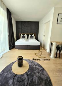 ein Schlafzimmer mit einem Bett und einem Tisch in einem Zimmer in der Unterkunft Bird Home Room 9 in Klagenfurt am Wörthersee