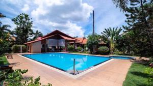 una piscina frente a una casa en Bangsaray Village Resort en Ban Nong Chap Tao