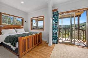 a bedroom with a bed and a balcony at Remutaka retreat in Upper Hutt