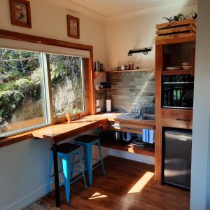 uma cozinha com uma mesa, uma janela e um lavatório em Remutaka retreat em Upper Hutt