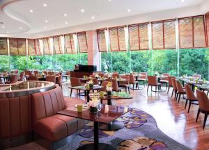 a restaurant with tables and chairs and large windows at DoubleTree by Hilton Shanghai Pudong - Present welcome cookie in Shanghai