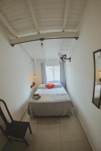 ein Schlafzimmer mit einem Bett und einem Stuhl in einem Zimmer in der Unterkunft Lagoa Nômade Hostel in Florianópolis