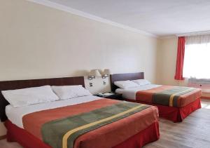 a hotel room with two beds and a window at Hotel Diego De Almagro Rancagua in Rancagua