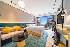 a hotel room with a bed and a couch at Hilton Garden Inn Chengdu Kuanzhai Alley in Chengdu