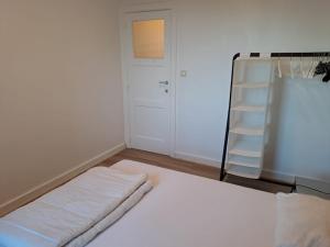 a bedroom with a white bed and a ladder at Appartement met prachtig zicht op zee in Ostend