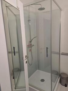 una doccia con una porta in vetro in un bagno di Appartement met prachtig zicht op zee a Ostenda