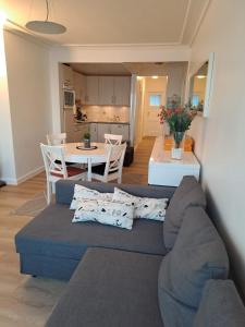 - un salon avec un canapé bleu et une table dans l'établissement Appartement met prachtig zicht op zee, à Ostende
