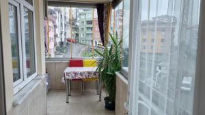 a table and chairs in a balcony with a window at Doğal apart in Trabzon