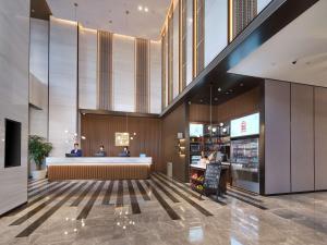 Hilton Garden Inn Hangzhou Xixi Zijingang في هانغتشو: لوبي محل فيه ناس جالسين في كونتر