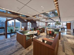 a restaurant with tables and chairs and windows at Hilton Garden Inn Hangzhou Xixi Zijingang in Hangzhou