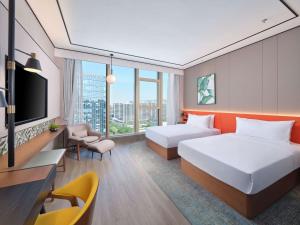 pokój hotelowy z dwoma łóżkami i telewizorem w obiekcie Hilton Garden Inn Hangzhou Xixi Zijingang w mieście Hangzhou