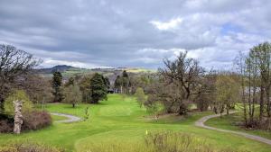 a golf course with trees and a winding road at Cameron Lodge in Balloch