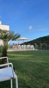 a white bench sitting on a lawn with tables and chairs at BLUE BOUTIQUE in Vietri