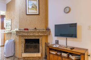 a living room with a fireplace and a flat screen tv at Villagio de Fiore - Stay House Temporada in Gramado