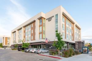 un edificio de oficinas con coches estacionados en un estacionamiento en Homewood Suites By Hilton Sunnyvale-Silicon Valley, Ca, en Sunnyvale