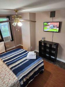 Home near University City في فيلادلفيا: غرفة نوم بسرير وتلفزيون بشاشة مسطحة