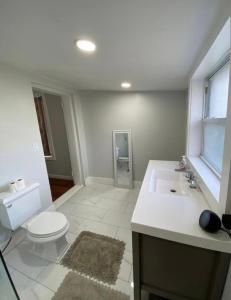 Baño blanco con aseo y lavamanos en Home near University City, en Filadelfia