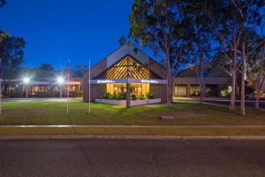 budynek z znakiem przed nim w nocy w obiekcie DoubleTree by Hilton Alice Springs w mieście Alice Springs