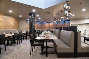 a dining room with tables and chairs and chandeliers at DoubleTree by Hilton Alice Springs in Alice Springs