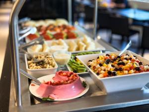 a buffet line with many different types of food at Hotel Gran Vivenzo Belo Horizonte in Belo Horizonte