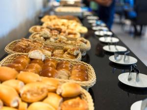 a row of baskets of pastries on a table at Hotel Gran Vivenzo Belo Horizonte in Belo Horizonte +63 photos