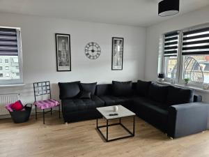 - un salon avec un canapé noir et une table dans l'établissement Apartament Flover, à Jelenia Góra