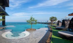 une piscine avec un arbre au milieu dans l'établissement Hilton Pattaya, à Pattaya