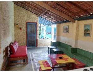 een woonkamer met een rode bank en een tafel bij Hostel Descanso dos Amigos Reserve Quarto Completo in Prado