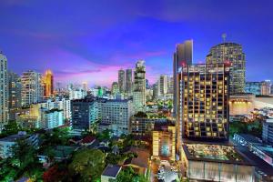 um horizonte da cidade à noite com edifícios altos em DoubleTree by Hilton Sukhumvit Bangkok em Bangkok
