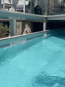 a swimming pool with blue water in front of a building at Luxury Villa Cañadas in Guadalajara