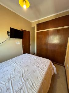 1 dormitorio con 1 cama y pared de madera en Departamento Céntrico bis en Goya