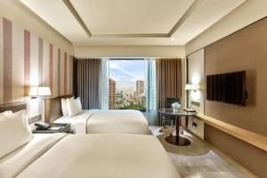 una camera d'albergo con due letti e una finestra di DoubleTree by Hilton Sukhumvit Bangkok a Bangkok