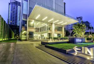 un gran edificio en una ciudad por la noche en Hilton Sukhumvit Bangkok, en Bangkok