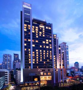 曼谷的住宿－曼谷素坤逸希爾頓酒店，一座高大的建筑,城市里灯火通明