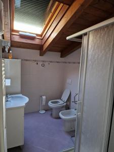 La salle de bains est pourvue de toilettes, d'un lavabo et d'une fenêtre. dans l'établissement DIANA HOUSE, à Colazza