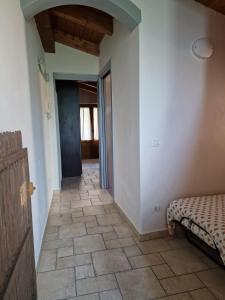 un couloir avec une chambre avec un lit et une porte dans l'établissement DIANA HOUSE, à Colazza