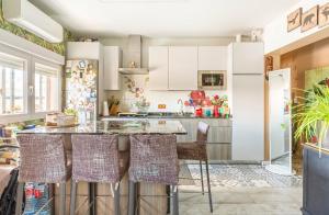 eine Küche mit weißen Schränken und eine Insel mit Stühlen in der Unterkunft Habitación con baño compartido in Madrid