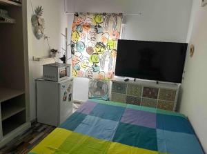 ein Schlafzimmer mit einem Bett mit einer bunten Decke in der Unterkunft Habitación con baño compartido in Madrid