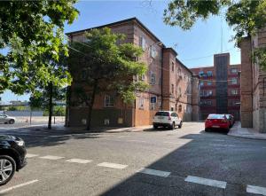 uma rua com carros estacionados em frente a um edifício em Habitación con baño compartido em Madri