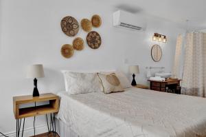 - une chambre dotée d'un grand lit blanc avec des plaques murales dans l'établissement Cozy Kingsville Country Home Guest House, à Kingsville