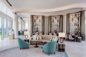 a lobby of a hotel with a couch and chairs at Waldorf Astoria Bangkok in Bangkok