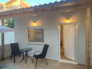 a patio with chairs and a table and a window at Little Home in Potos