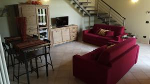 a living room with red furniture and a staircase at LA CASA IN CAMPAGNA esclusiva in Calosso