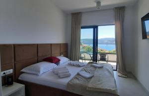 Schlafzimmer mit einem Bett und Blick auf einen Balkon in der Unterkunft Villa Danny in Komarna