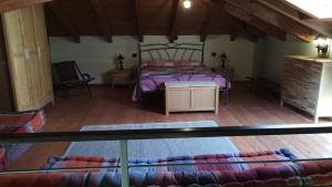 una camera con letto e pavimento in legno di LA CASA IN CAMPAGNA esclusiva a Calosso