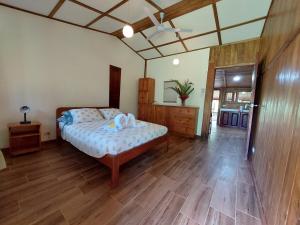 een slaapkamer met een bed en een houten vloer bij Casa Mairena in Caño Negro