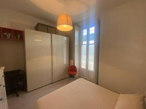 1 dormitorio con 1 cama, armario y silla roja en Casa Sobborghi en Monza