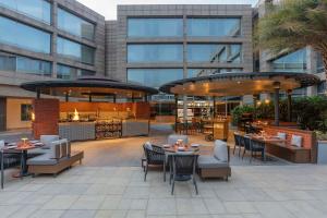 a patio with tables and chairs in a building at Hilton Bangalore Embassy GolfLinks in Bangalore