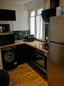 uma cozinha com uma máquina de lavar roupa, um lavatório e uma máquina de lavar louça em Bas de Maison em Biguglia