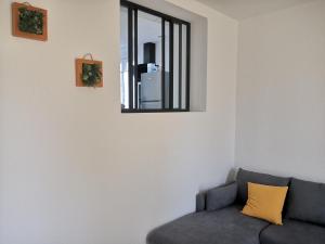 uma sala de estar com um sofá e uma janela em Bas de Maison em Biguglia